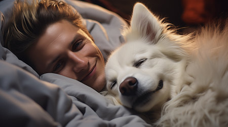 Portrait of young man with his dog in bed at home.の素材