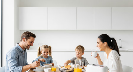 happy family having breakfast in kitchen at home together, parents and childrenの素材