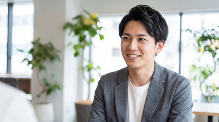 Portrait of young asian businessman smiling at camera in coffee shopの素材
