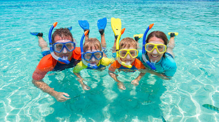 Happy family with snorkeling equipment at tropical beach in summer vacationの素材