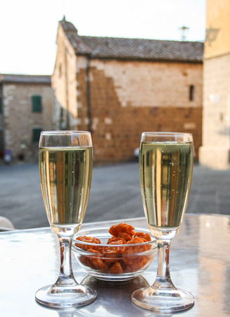 two flutes of Prosecco wine on the background of a square tuscanyの写真素材