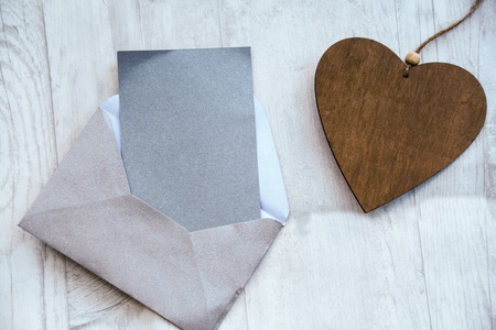 romantic background; blank card with a wooden heart on a white wooden background