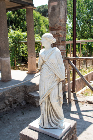 AT POMPEI - ON 06/22/ 2017 - Statue in the backyard of a villa in the  ancient roman town of Pompeii, destroyed by vesuvius eruption in 70 d.c.のeditorial素材