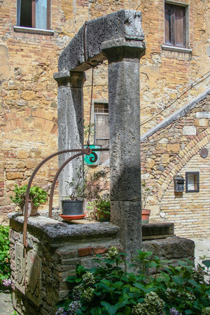 Old well in a courtryard in Tuscany, Siena, Italyの写真素材