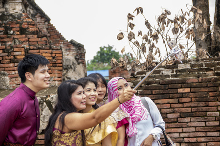 At Ayutthaya - Thailand - On august 2018 - group of  people taking selfies in traditional thai clothes in the Buddhist temple called Wat Chaiwatthanaramのeditorial素材