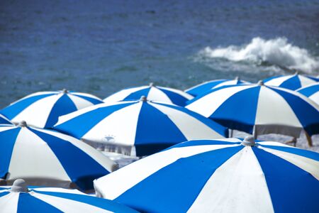 blue and white beach umbrellas on the background of sea at Maratea, Italyの写真素材