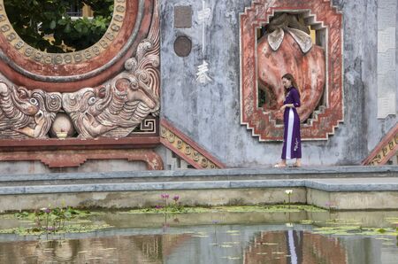 At Hoi An, Vietnam , on august 2019 -  Girl reflecting in the fountain of Tam Quan gate, or three-entrance gate, leading  to the old temple complex built in 1626 and known as Ba Mu Templeのeditorial素材