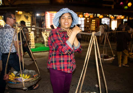 At Hoi An - Vietnam - On august 2019 - woman carrying  goods on her shouldersのeditorial素材