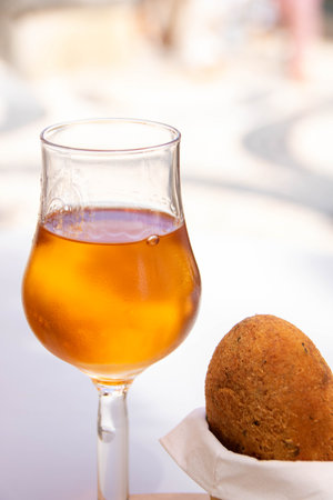 traditional codfish fried ball served with a glass of Porto wineの写真素材