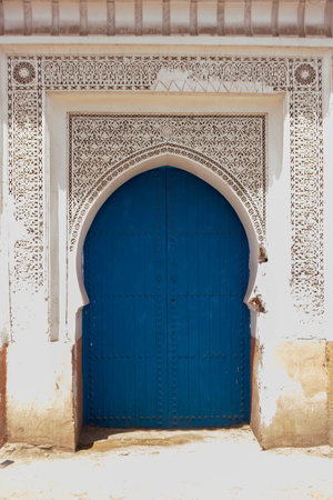 Bright blue wooden door on an old palace of the Medina of Marrakech, Morocco