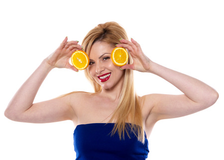 the blond woman with the orange isolated on the white backgroundの写真素材