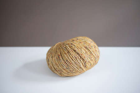 Ball of tweed yarn in daylight on white table. closeup, bright.の写真素材