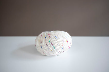 Ball of dotted yarn on white table in daylight. closeup, bright.の写真素材
