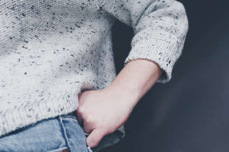 Woman wears knit sweater and jeans. hands on hips.の写真素材