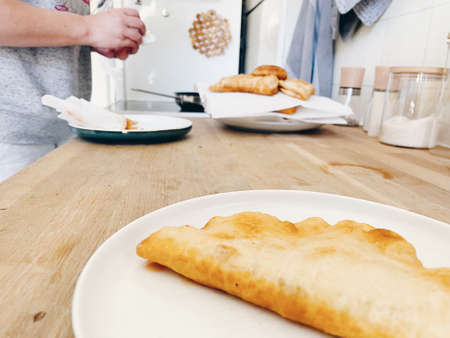 Woman prepares Italian Panzerotti. Daylight kitchen.の写真素材