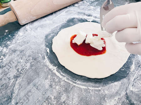 Woman prepares Italian Panzerotti. Daylight kitchen.