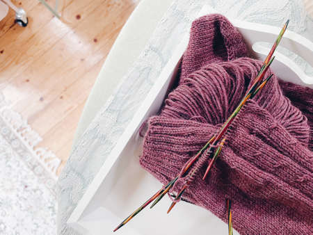 Knitting socks needles and wool on table in daylight.の写真素材