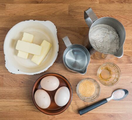 Baking cake in kitchen - dough recipe ingredients (eggs, flour, water, butter, sugar, vanilla) on...