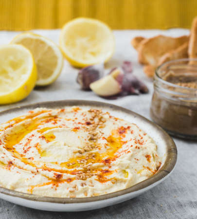 Healthy Homemade Creamy Hummus with the ingredients. Side view. Mediterranean dish made of chickpea beansの写真素材