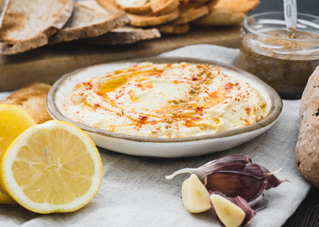 Healthy Homemade Creamy Hummus with the ingredients. Side view. Mediterranean dish made of chickpea beansの写真素材