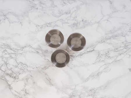 Muffins metal mold on a marble counter, top viewの写真素材