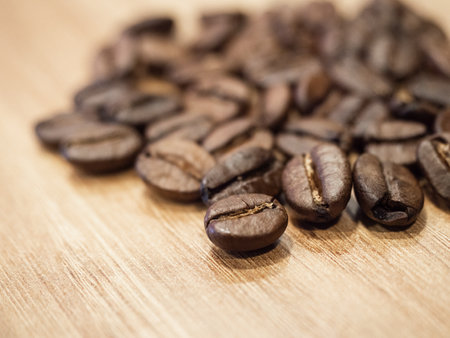 Loose coffee beans over a wooden counter, macro viewの写真素材