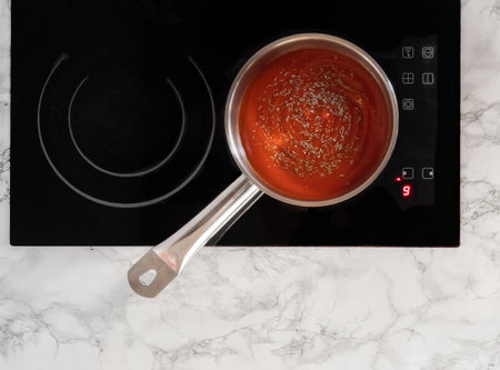 Tomato sauce in a pot on top of the stove. View form above.