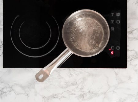 Boiling water in a ladle. Pot on top of the stove with boiling water. View from above.の写真素材