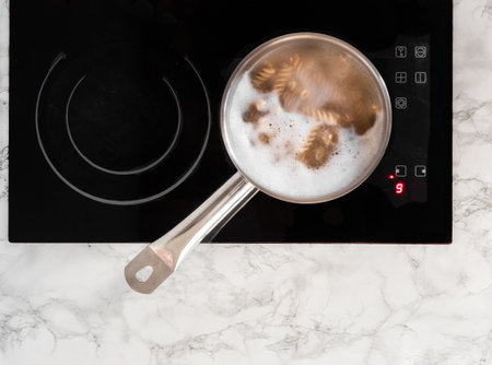 Boiling pasta in a pot. Pot on top of the stove with boiling pasta. View from above.の写真素材