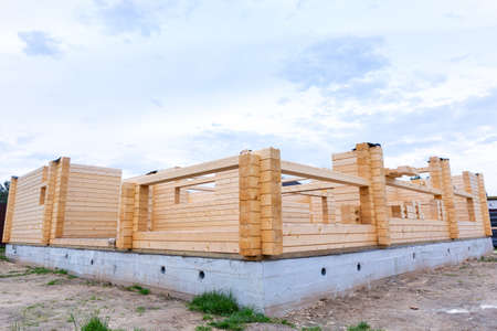 Construction of a wooden house on a cement base, foundation. Suburban real estate, eco house,...