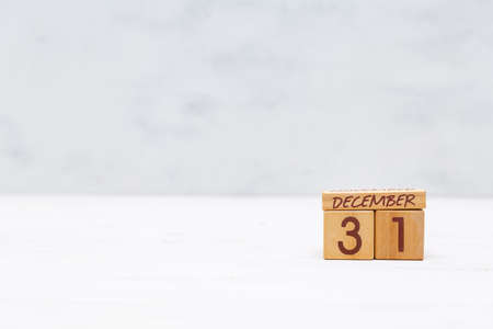 Calendar from wooden cubes with the date of December 31 on a light gray background. New year, end of...