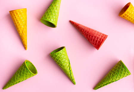 Wafer multicolored empty ice cream cones on pink background, flat lay.の写真素材