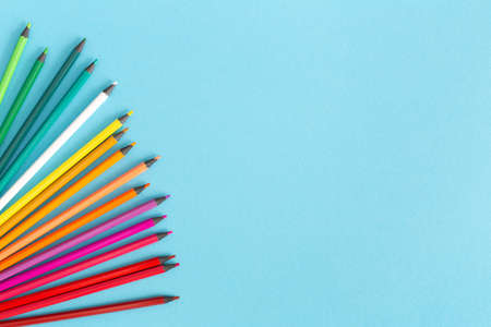 Multicolored pencils on a blue background, copy space.