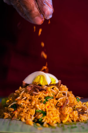 Hand Pouring Nasi Goreng or Fried Rice Traditional Food Isolatedの写真素材