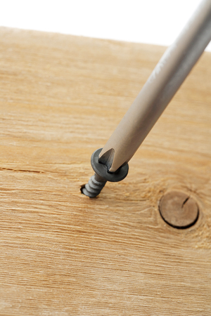screw driven by screw driver to a woodの写真素材