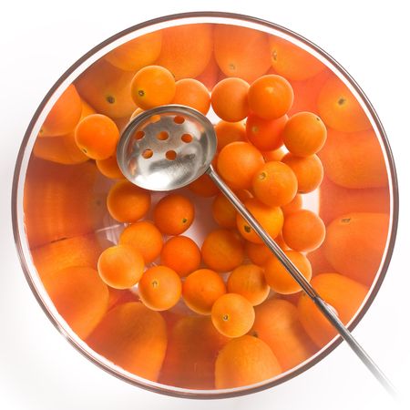Cherry tomatoes in a glass salad bowl over white backgroundの写真素材