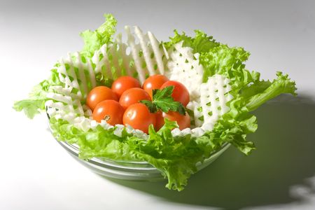 Vegetables salad in a glass salad bowl over white backgroundの写真素材