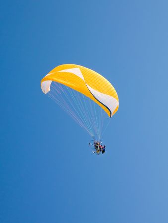 Yellow paraglider with motor  in serene cloudless blue skyの写真素材