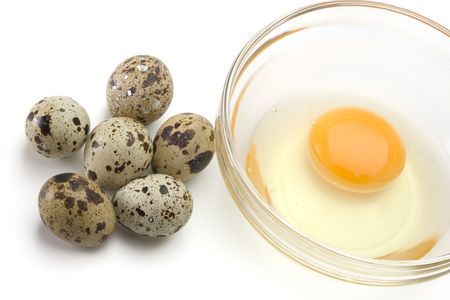 Dish of liquid egg and quail eggs over white backgroundの写真素材