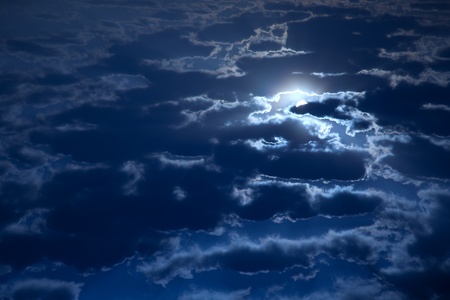 Night sky, full moon and fluffy clouds in a moonlightの写真素材