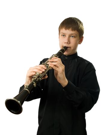 The teenager playing on a clarnet. It is isolated on a white background.の写真素材