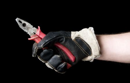 Pliers in a hand on a black background.