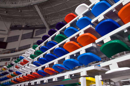 Several rows of multi-coloured plastic stadium seats