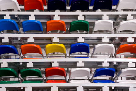 Several rows of multi-coloured plastic stadium seatsの写真素材