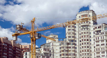 The building crane on a background of modern houses