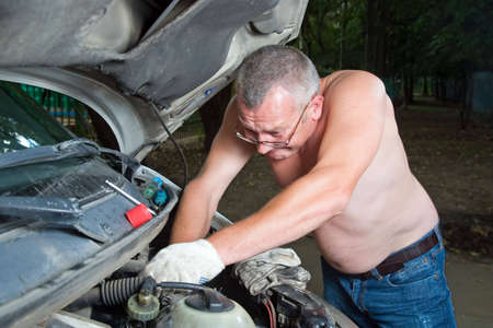 Man mechanic repairing his car on the roadの写真素材