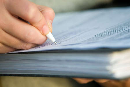 Businesswoman signing documents. Close-up of hands.