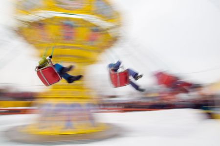 Group of kids riding the spinning swing at an amusement parkの写真素材