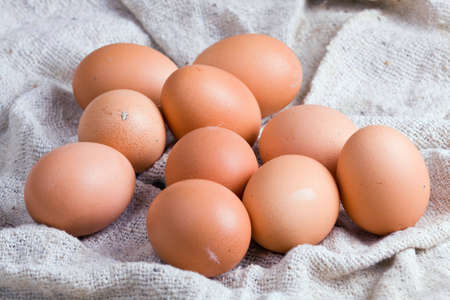 Ten chicken eggs laying on a sacking