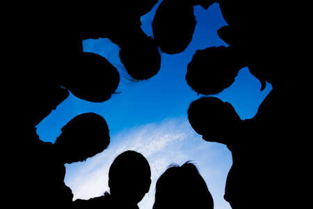 Silhouette of a group of eight people against the sky